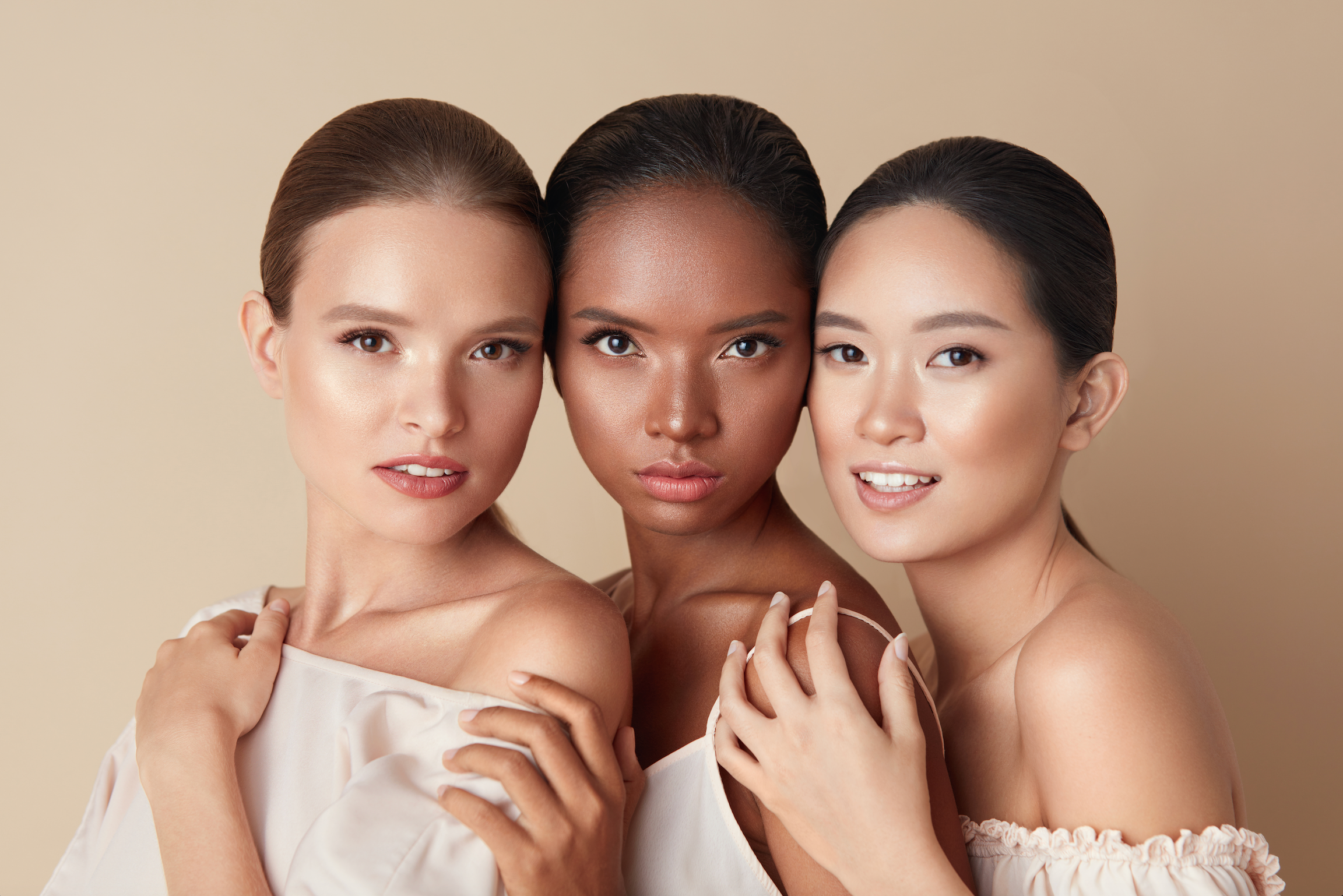 3 Frauen die Ihr Gesicht beisammen halten bei einem Beauty Shooting